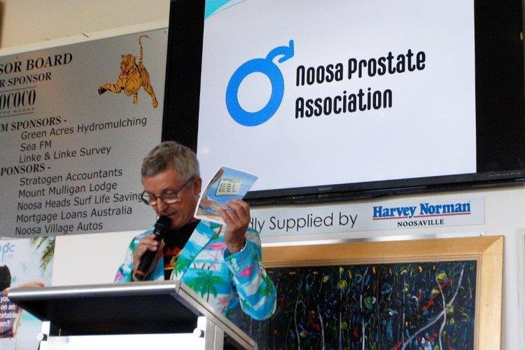 Ian Miller presenting holding up a check at the Noosa Prostate Association Fundraiser 2019