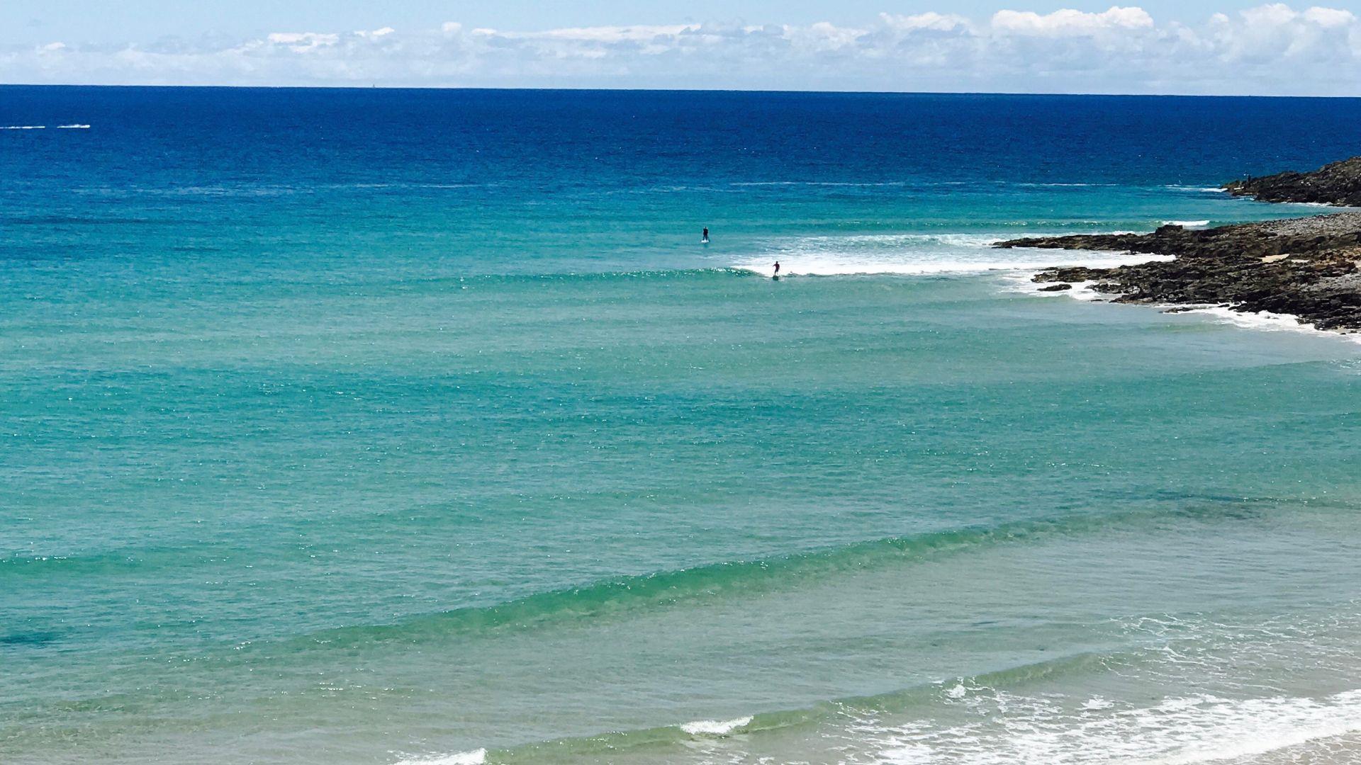 Surfers in the distance at Noosa